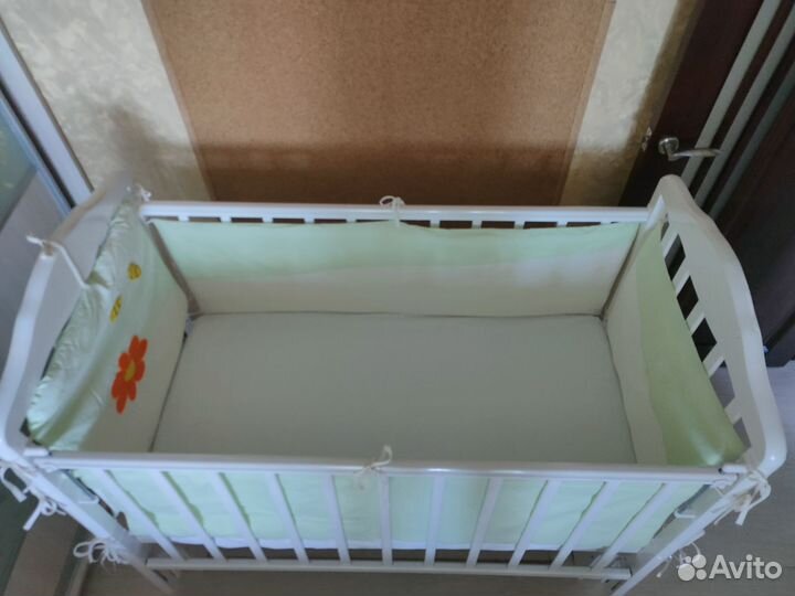 Белая детская кроватка с маятником