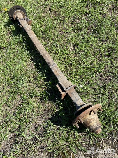 Ось тракторного прицепа с колесами