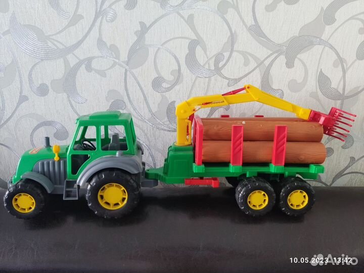 Трактор с прицепом, бревнами и цепляющим краном