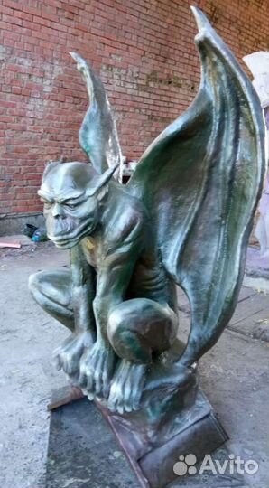 Горгулья сидит на камне - скульптура