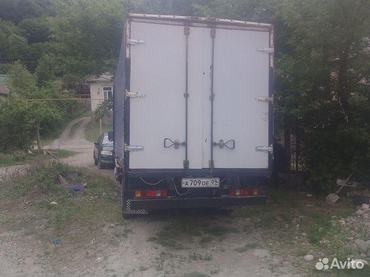 Водитель на своем грузовом автомобиле газель