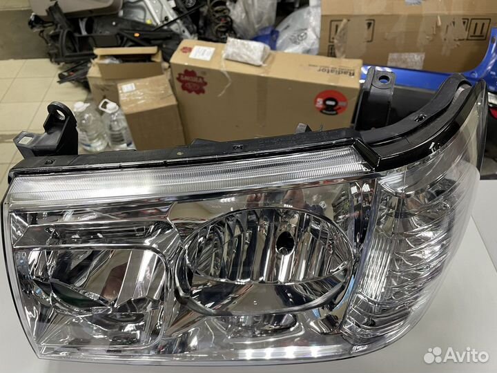 Фара левая Toyota Land Cruiser 100 212-11H9L-LD-EM