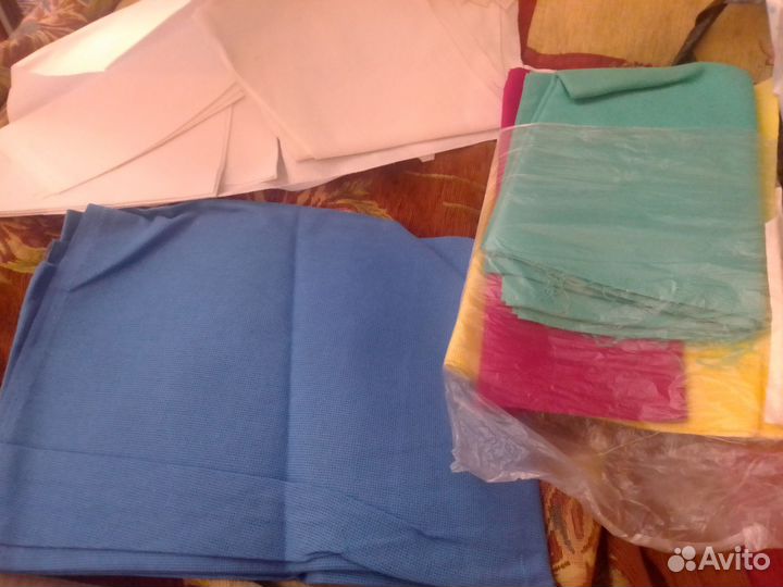 Много ниток и канвы для вышивки