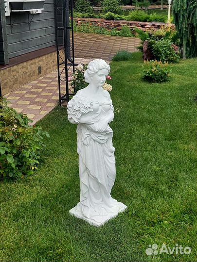 Статуя девушки из бетона с букетом