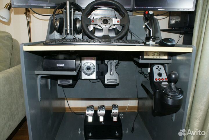 Компьютерный стол с мониторами и джойстиками